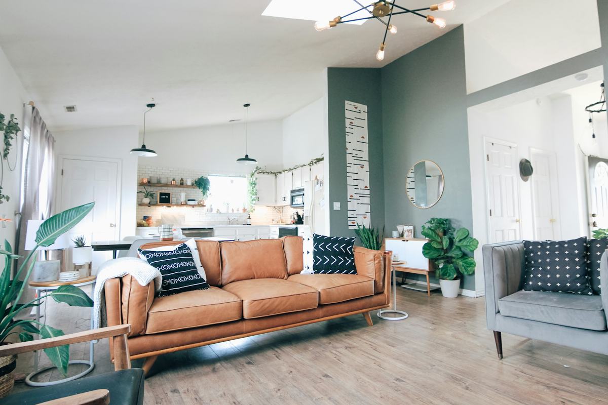 Bright contemporary sitting room with a soft sofa, warm wood flooring and greenery